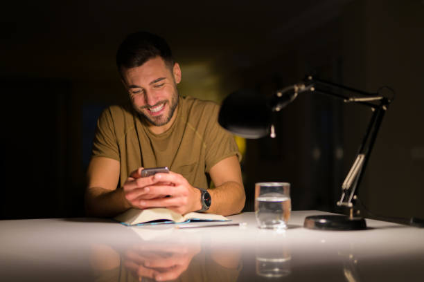 istock Young handsome man studying at home , using smartphone, looking at the phone smiling 1143492128