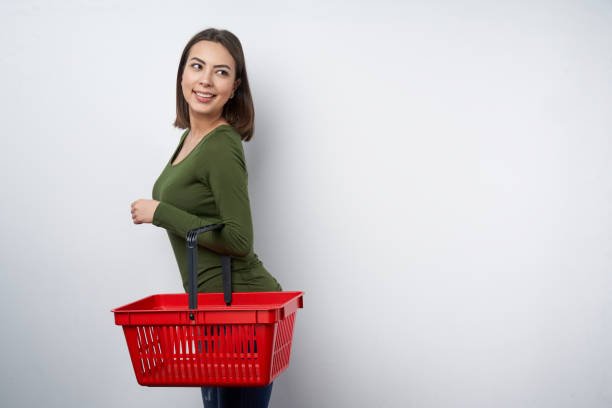 istock Woman holding empty shopping basket looking aside 1143494631