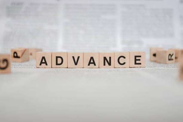 istock Advance Word Written In Wooden Cube - Newspaper 1143495888