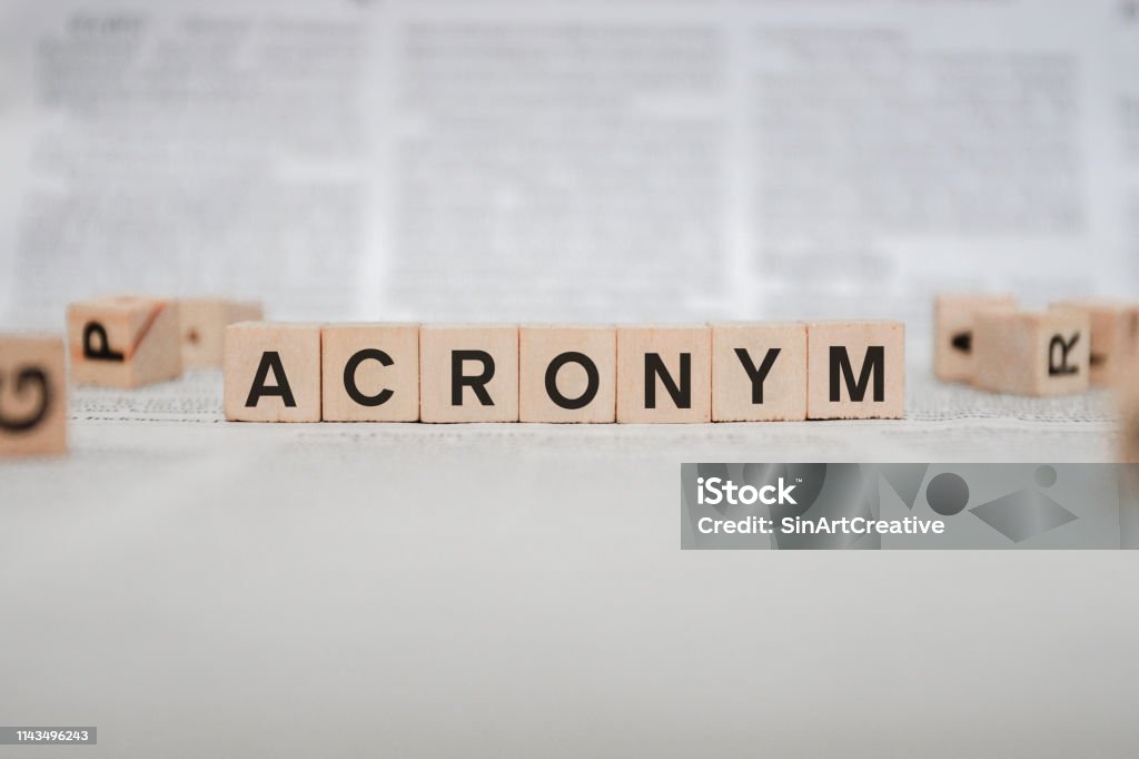 Acronym Word Written In Wooden Cube - Newspaper Acronym Stock Photo