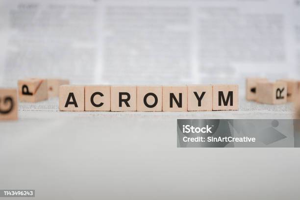 Acronym Word Written In Wooden Cube Newspaper Stock Photo - Download Image Now - Acronym, Alphabet, Learning