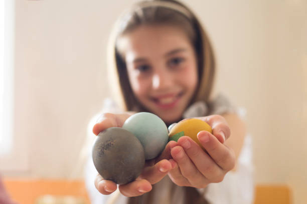 Mother and daughter decorate Easter eggs at home, using Eco friendly organic colors and other natural material
