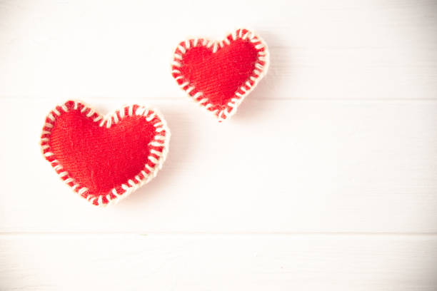 istock Red knitted soft fabric hearts on white background 1143497871