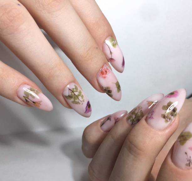istock Female manicure with flower design on nails close up 1143500188