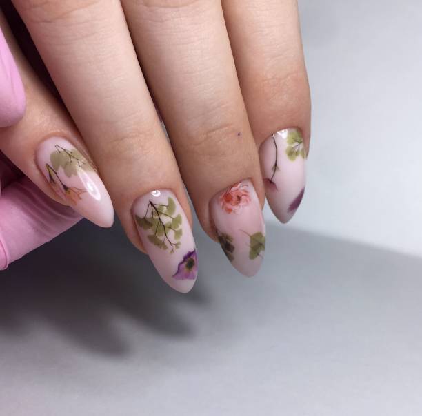 istock Female manicure with flower design on nails close up 1143500630