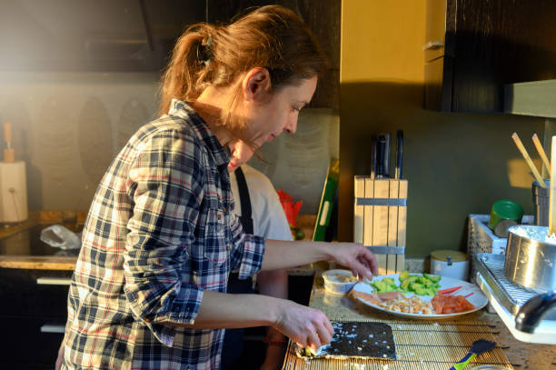 istock Woman prepares sushi 1143501266