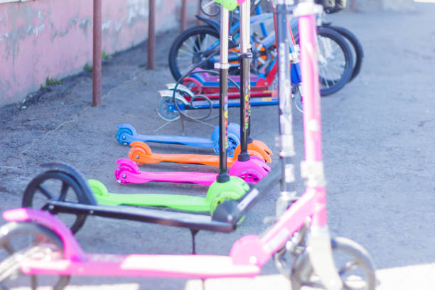 istock children's scooters and bicycles stand in a row on the sidewalk 1143503772