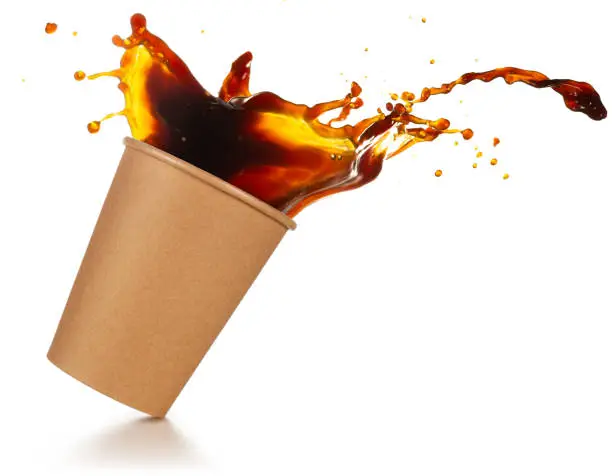 coffee splashing out of a take-out cup tilted on white background