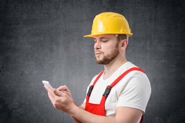 ouvrier de construction utilisant le smartphone - men mail manual worker human hand photos et images de collection