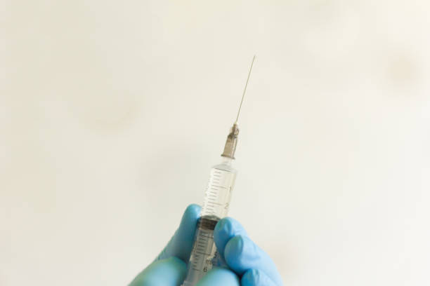 istock doctor's hand in gloves holding a syringe with medication for injection 1143506978