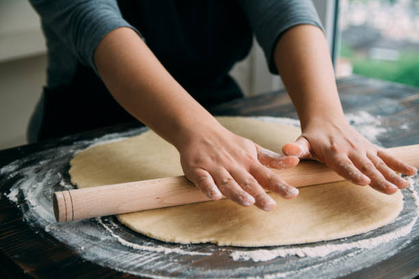 istock Woman rolling dough on wooden table 1143507963