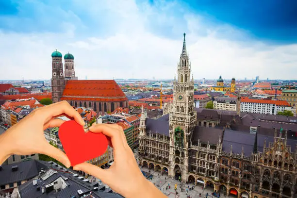 Photo of Hand hold red heart over Neues Rathaus in Munich