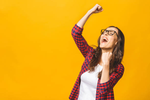 istock Winning success woman happy ecstatic celebrating being a winner. Dynamic energetic image of multiracial Caucasian Asian female model isolated on yellow background waist up. 1143509983