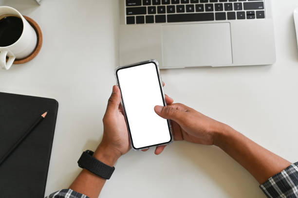 istock Cropped shot hands using mockup smartphone on office desk with clipping path. 1143510000