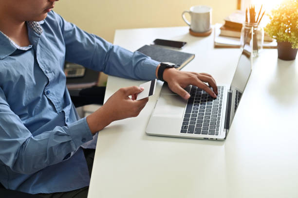 istock Cropped shot of man input credit card information while shopping online. 1143510063