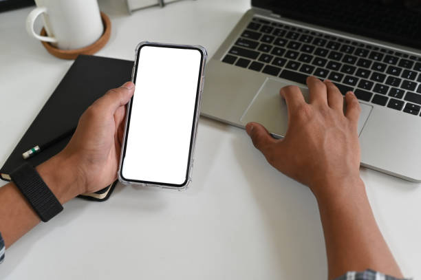 istock Cropped shot hands using mockup smartphone on office desk with clipping path. 1143510755