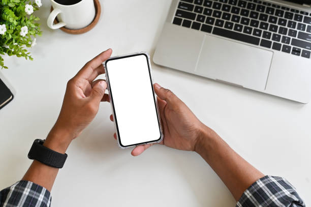 istock Cropped shot hands using mockup smartphone on office desk with clipping path. 1143511262