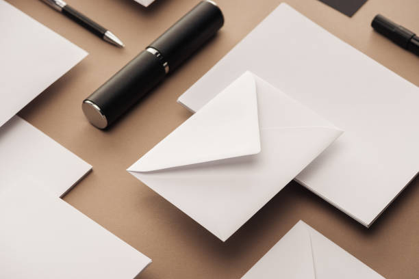 istock Empty sheets of paper, case, pen and envelopes on beige background 1143512612