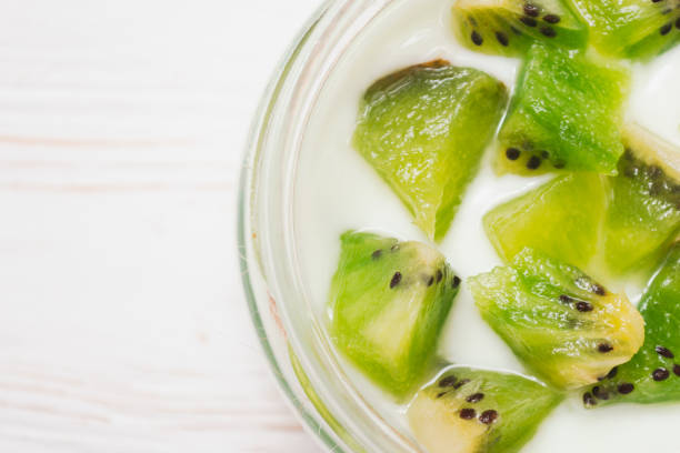 istock Yogurt with kiwi slices on a wooden white background. 1143512620