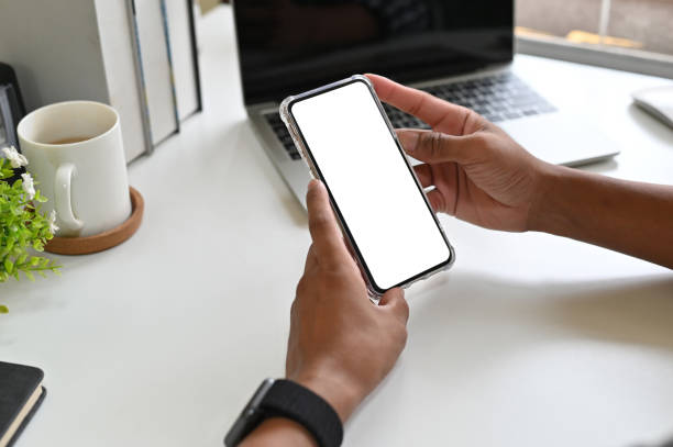 istock Cropped shot hands using mockup smartphone on office desk with clipping path. 1143512720