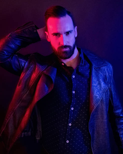 istock Handsome man wearing a leather jacket with blue and red gel lighting 1143512973