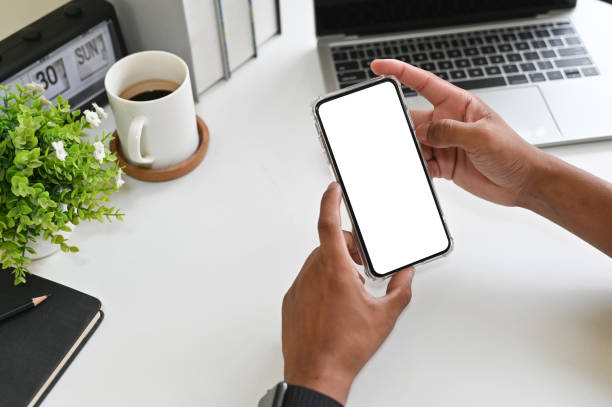 istock Cropped shot hands using mockup smartphone on office desk with clipping path. 1143513046