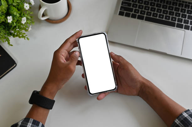istock Cropped shot hands using mockup smartphone on office desk with clipping path. 1143513611
