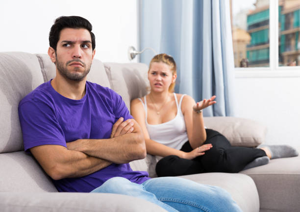 istock Frustrated guy on couch with dissatisfied girlfriend 1143513643