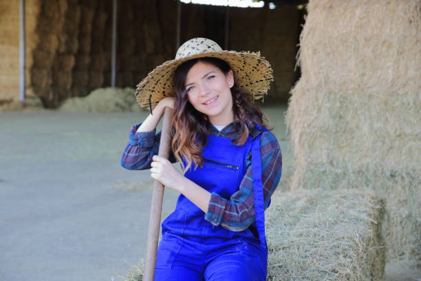istock Woman farmer working with hay fork 1143513886