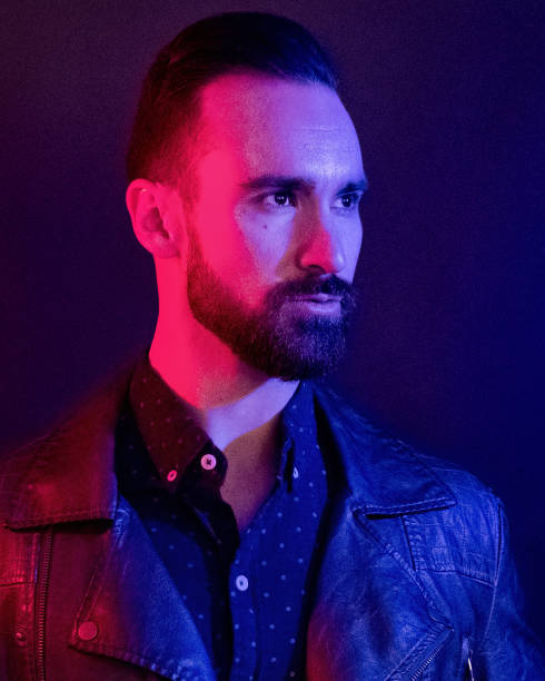 istock Handsome man wearing a leather jacket with blue and red gel lighting 1143513894