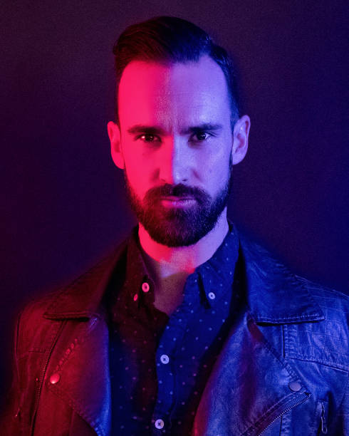 istock Handsome man wearing a leather jacket with blue and red gel lighting 1143513906