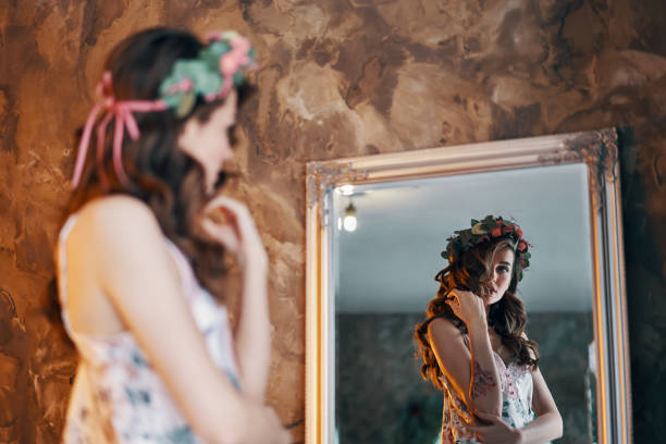 istock Beautiful young woman looking at her reflection in the mirror 1143514617