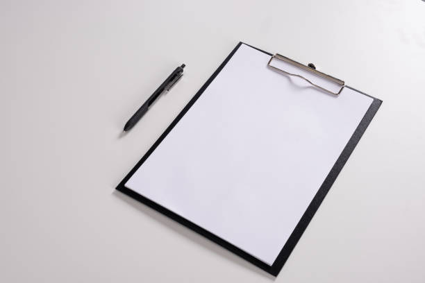 istock Tablet with writing paper with pen on white table 1143516516