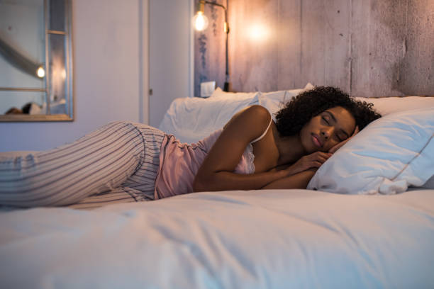 istock Beautiful black woman lying down on bed sleeping 1143516638