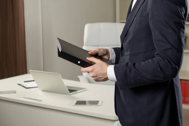 istock Businessman holding a book, dark background 1143516896