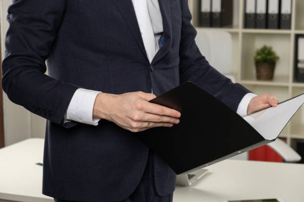 istock Businessman holding a book, dark background 1143516965
