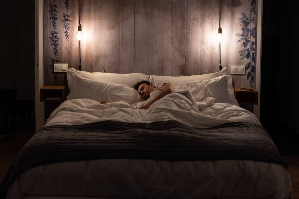 istock Man sleeping in bed in a modern beautiful bedroom 1143519985
