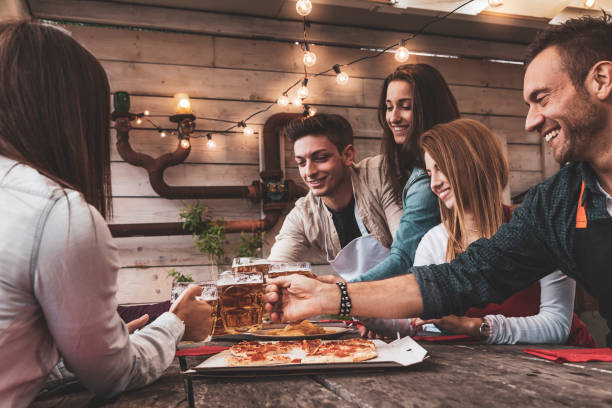 Happy group of friends drinking beer stock photo