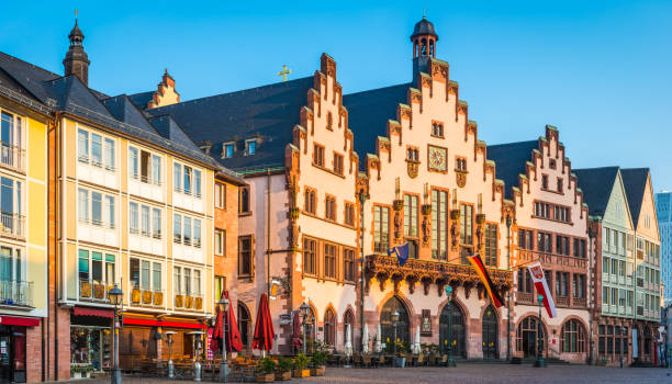 Warmes Tageslicht beleuchtet die mittelalterliche Fassade des Romer Rathauses mit Blick auf den Platz von Romerberg in der historischen Alstadt von Frankfurt am Main, Deutschland.