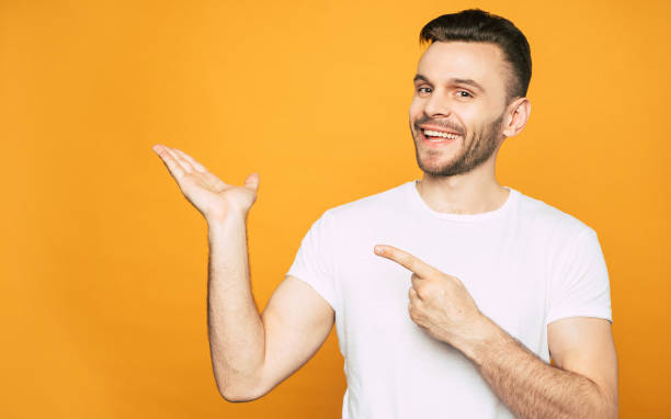 istock Watch it! Full of pleasant emotions boy in white basic T-shirt is pointing on something what he   really enjoys and recommend 1143523148