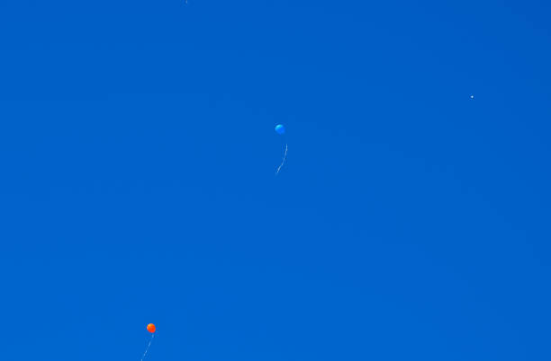 istock Multicolored balls, filled with helium, fly in the blue sky 1143523702