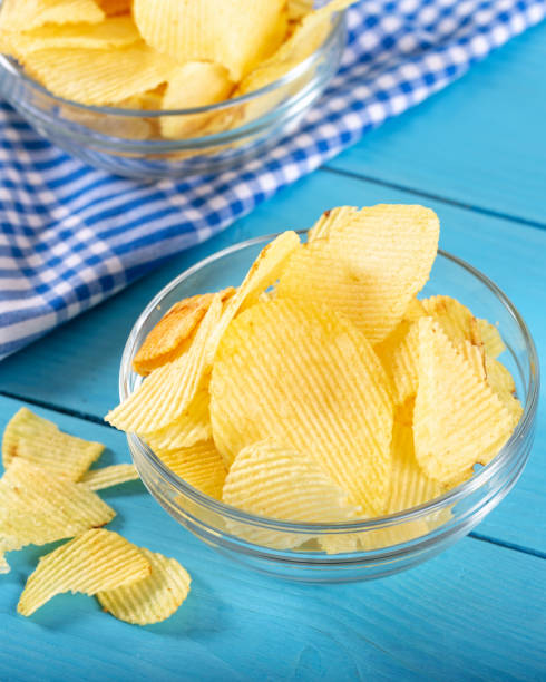 istock Potato chips in glass window on wooden background 1143524221