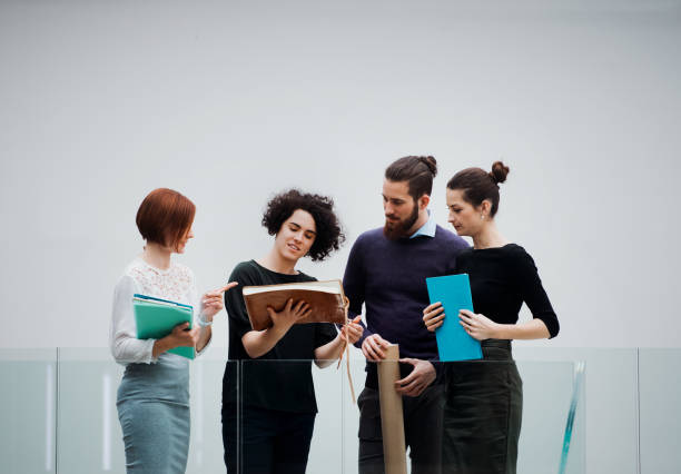 istock Group of young businesspeople standing in an office, talking. 1143526647