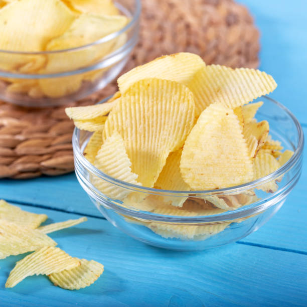 istock Potato chips in glass window on wooden background 1143526893