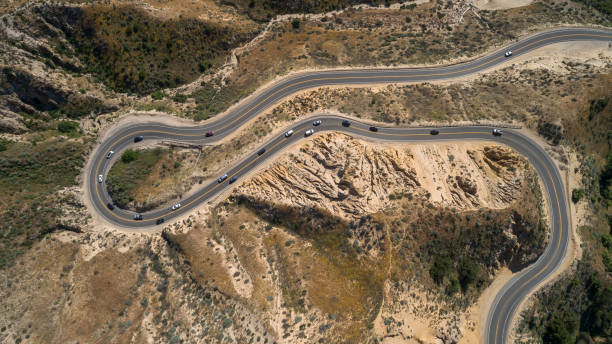 strong traffic on the twisted mountain highway grimes canyon road nearby moorpark, california. top view aerial picture. - twisty road imagens e fotografias de stock