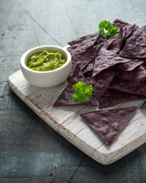 istock Blue corn Organic tortilla chips with Guacamole on white wooden board 1143529033