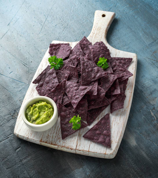 istock Blue corn Organic tortilla chips with Guacamole on white wooden board 1143529051