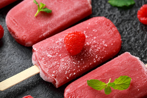 istock Homemade raspberry popsicles, ice lolly on rustic black background 1143530117