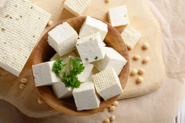 istock Flat lay view at Soy Bean curd tofu in wooden bowl on kitchen table. Non-dairy alternative substitute for cheese 1143531377