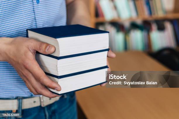 Male Hands Holding A Stack Of Books Stock Photo - Download Image Now - Advice, Angle, Arm